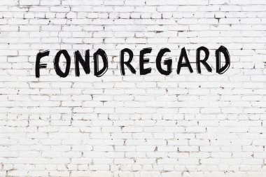 Yazılı beyaz tuğla duvar. Siyah boyayla yazılmış.