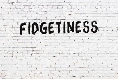 Üzerinde yazı olan beyaz tuğla duvar, el yazısıyla siyah boya.