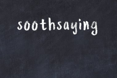 Beyaz tuğlalı duvar. Kahin el yazısıyla siyah boyayla yazılmış.