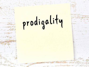 Müsrifliği hatırlatma kavramı. Tahta duvarda üzerinde yazı olan sarı yapışkan kağıt.