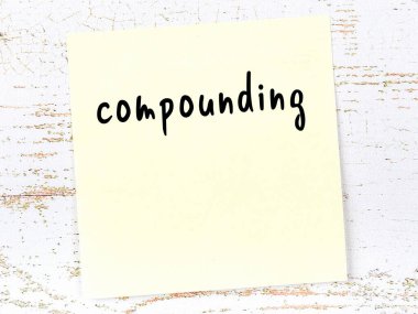 Bileşikleşme hakkında hatırlatma kavramı. Tahta duvarda üzerinde yazı olan sarı yapışkan kağıt.