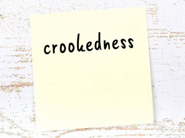 Tahta duvardaki sarı yapışkan notta el yazısıyla yazılmış eğrilik var.