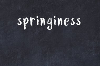 White brick wall with inscription springiness handwritten with black paint