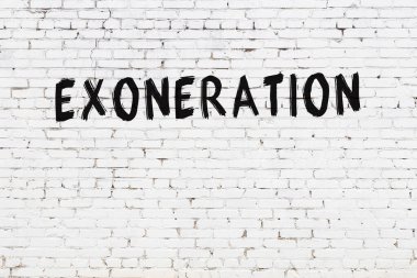 White brick wall with inscription exoneration handwritten with black paint