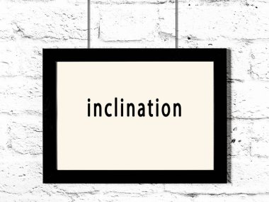 Black wooden frame with inscription inclination hanging on white brick wall 