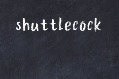 White brick wall with inscription shuttlecock handwritten with black paint