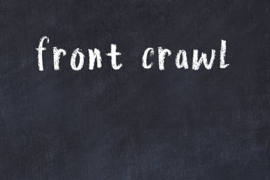 White brick wall with inscription front crawl handwritten with black paint