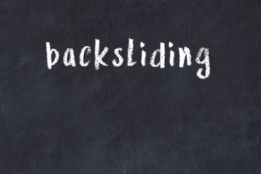 Beyaz tuğla duvara siyah boya ile yazılan yazılar.