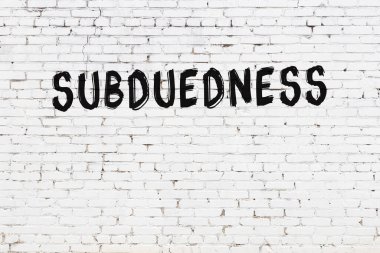 Inscription subduedness written with black paint on white brick wall.