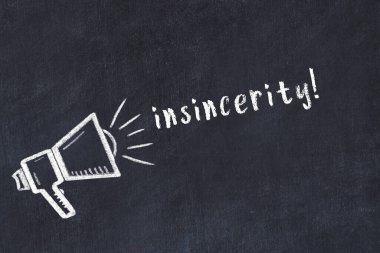 Chalk drawing of loudspeaker and handwritten inscription insincerity on black desk