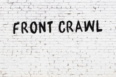 Inscription front crawl written with black paint on white brick wall.