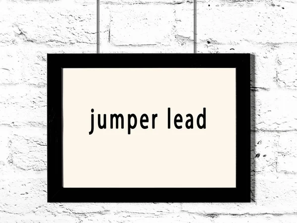 Black Wooden Frame Inscription Jumper Lead Hanging White Brick Wall — Stockfoto