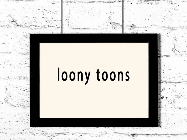 Black Wooden Frame Inscription Loony Toons Hanging White Brick Wall — Stockfoto