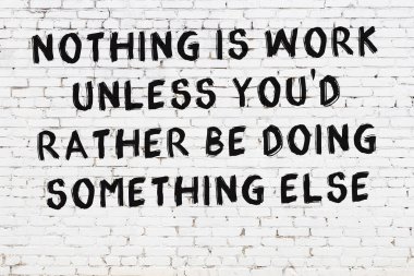 Beyaz tuğla duvar ve bilgece alıntıların yazılı olduğu siyah yazı.