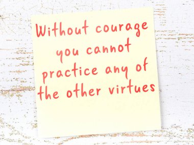 Tahta duvarda el yazısı motivasyon alıntısı olan sarı yapışkan not