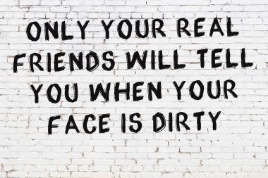 Beyaz tuğla duvar ve bilgece alıntıların yazılı olduğu siyah yazı.