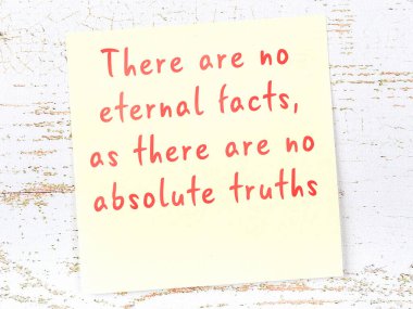 Sarı yapışkan not, ahşap duvarda el yazısıyla yazılmış zekice bir alıntıyla.