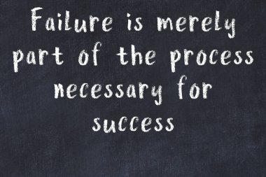 Siyah masa üzerine tebeşirle yazılmış zekice bir söz.