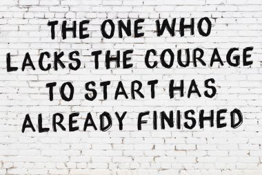 Üzerinde mantıklı alıntıların yazılı olduğu siyah boyanmış beyaz tuğla duvar.