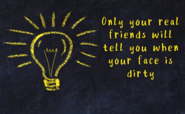 Bilgece bir alıntı ve siyah karatahtaya bir ampul çizimi