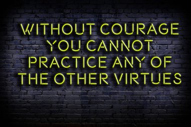 Tuğla duvardaki bilgece alıntıların neon yazıları üzerine gece görüşü