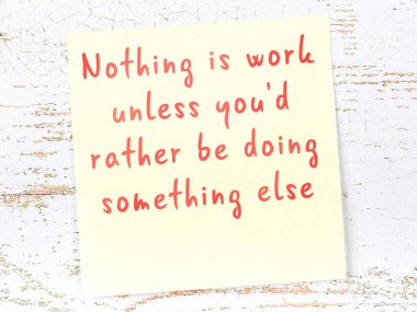 Sarı yapışkan not, ahşap duvarda el yazısıyla yazılmış zekice bir alıntıyla.