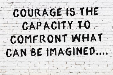 Üzerinde mantıklı alıntıların yazılı olduğu siyah boyanmış beyaz tuğla duvar.