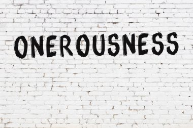 Beyaz tuğla duvarda siyah boyayla yazılmış yazıtlar..