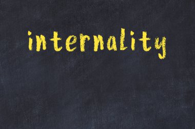 Tebeşir el yazısıyla yazılmış iç yazması siyah masanın üzerinde.