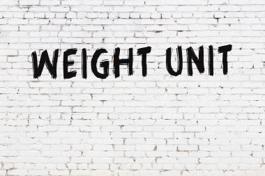 Beyaz tuğlalı duvar, yazıt ağırlığı birimi, el yazısıyla siyah boya.