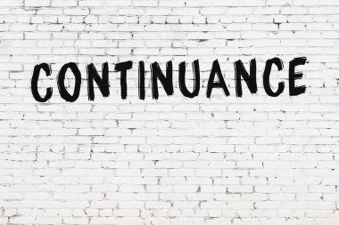 Siyah boyayla el yazısıyla yazılmış beyaz tuğla duvar.