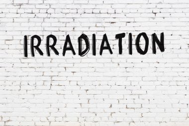 Beyaz tuğla duvara siyah boya ile yazılan radyasyon..