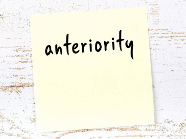 Tahta duvarda el yazısıyla yazılmış sarı yapışkan bir not var.