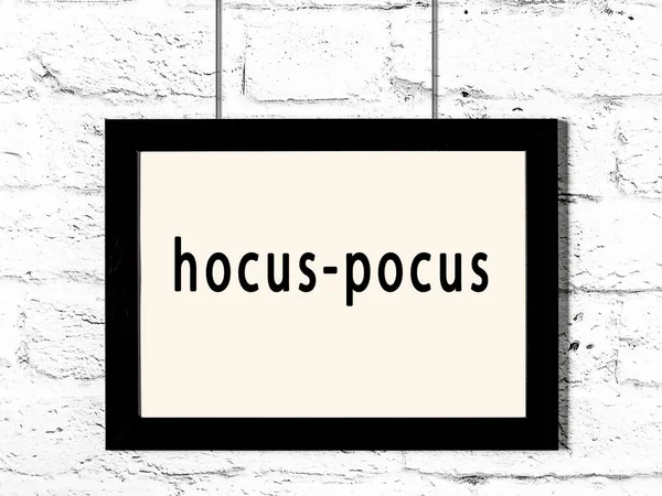 白色砖墙上挂着刻有 Hocus Pocus 字样的黑色木制框架 — 图库照片