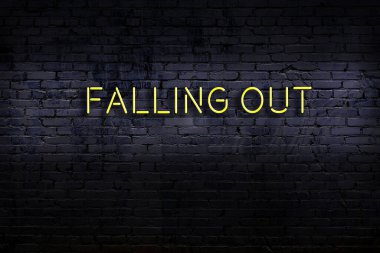 Üzerinde yazı olan neon levhası tuğla duvara çarpıyor. Gece görünümü