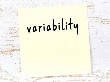 Değişkenliği hatırlatma kavramı. Tahta duvarda üzerinde yazı olan sarı yapışkan kağıt.