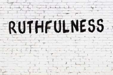 Beyaz tuğla duvara siyah boyayla yazılmış ruhani yazılar..