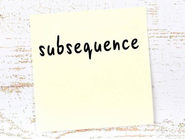 Tahta duvarda el yazısı alt dizilimle sarı yapışkan bir not var.