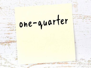 Tahta duvarda el yazısıyla yazılmış sarı yapışkan bir not var.