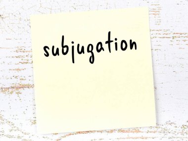 Tahta duvardaki sarı yapışkan notta el yazısıyla yazılmış boyun eğdirme.