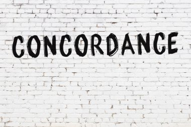 Siyah boyayla el yazısıyla yazılmış beyaz tuğlalı bir duvar.