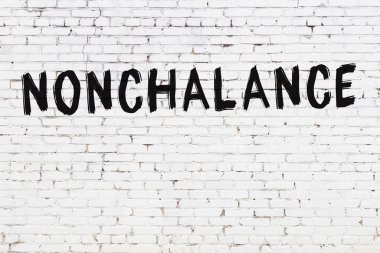 Yazılı beyaz tuğla duvar. Siyah boyayla yazılmış kayıtsızlık.