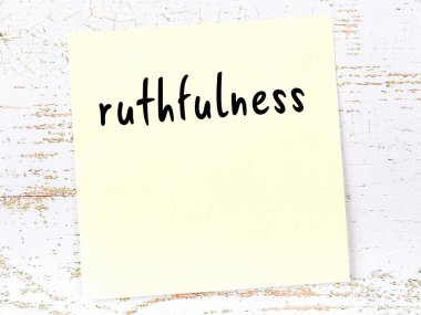 Acımasızlığı hatırlatma anlayışı. Tahta duvarda üzerinde yazı olan sarı yapışkan kağıt.