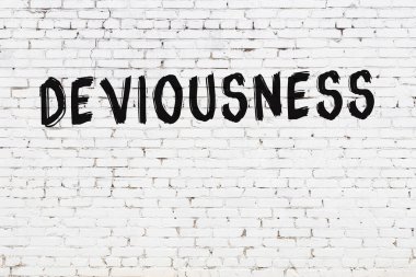 Yazı, beyaz tuğla duvara siyah boya ile yazılmış..