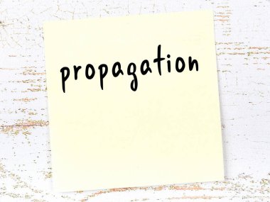 Tahta duvardaki sarı yapışkan notta elle yazılmış yazma yayılımı var.