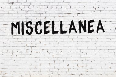 Beyaz tuğlalı duvara siyah boya ile yazılmış yazıtlar..