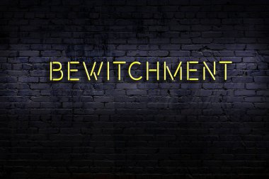 Üzerinde tuğla duvara karşı büyü yazan neon tabela. Gece görünümü