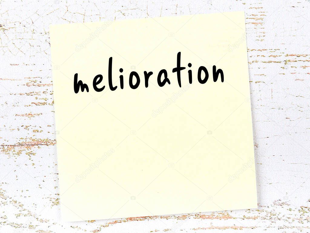 Concept of reminder about melioration. Yellow sticky sheet of paper on wooden wall with inscription