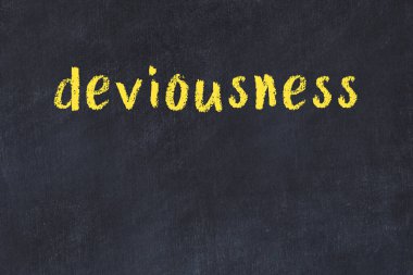 Tebeşir el yazısıyla yazılmış düzenbazlık siyah masada.