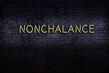 Üzerinde tuğla duvara karşı kayıtsızlık yazan neon tabela. Gece görünümü